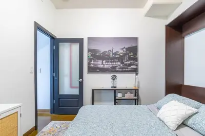 a bedroom with a bed and a blue door at Modern Beltline Escape Sky-High Views DT Views in Calgary