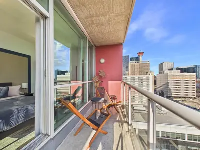 a balcony with a bed and a view of the city at Modern Beltline Escape Sky-High Views DT Views in Calgary