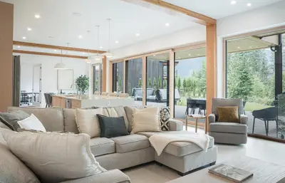 a living room with a large couch and a kitchen at Camozzi Chalet by Revelstoke Vacations in Revelstoke