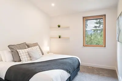 a bedroom with a large bed and a window at Camozzi Chalet by Revelstoke Vacations in Revelstoke