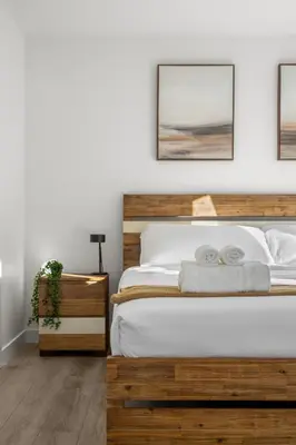 a bedroom with a wooden bed with two pillows at Full Townhouse Cozy Guest Favorite Garage Parking Aspen Neighbourhood in Calgary