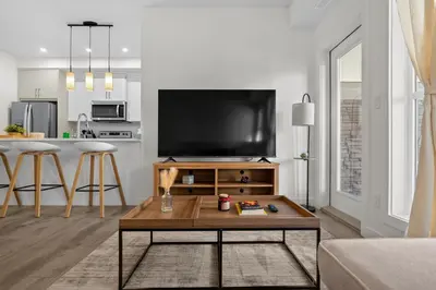 a living room with a tv and a coffee table at Full Townhouse Cozy Guest Favorite Garage Parking Aspen Neighbourhood in Calgary