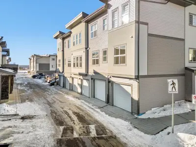 an apartment building with a no parking sign in the snow at Full Townhouse Cozy Guest Favorite Garage Parking Aspen Neighbourhood in Calgary