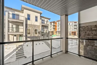 an apartment balcony with a view of a building at Full Townhouse Cozy Guest Favorite Garage Parking Aspen Neighbourhood in Calgary