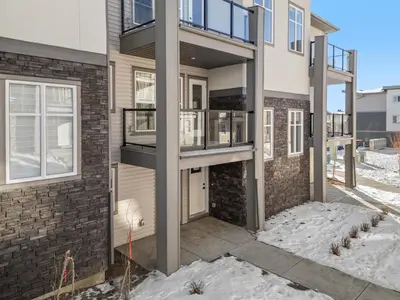 a apartment building with a balcony in the snow at Full Townhouse Cozy Guest Favorite Garage Parking Aspen Neighbourhood in Calgary
