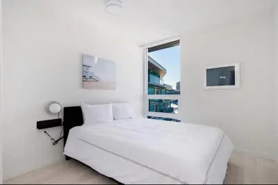 a white bedroom with a bed and a window at Peaceful City Stay, Calm Vibes in a Cozy in Vancouver