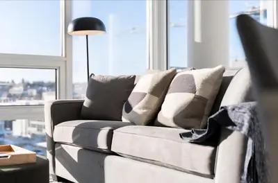 a couch with pillows in a living room with a window at Peaceful City Stay, Calm Vibes in a Cozy in Vancouver