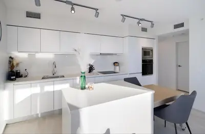 a kitchen with white cabinets and a white island at Peaceful City Stay, Calm Vibes in a Cozy in Vancouver