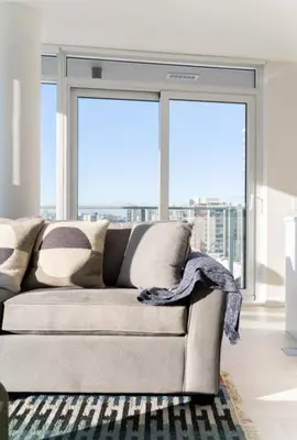 a living room with a couch and large windows at Peaceful City Stay, Calm Vibes in a Cozy in Vancouver