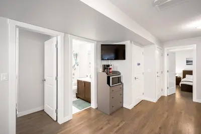 a living room with white walls and a tv on the wall at New 2BD Suite Near Events Center in Langley