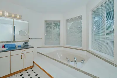 a large white bathroom with a tub and windows at The Coastal Garden Retreat in Delta