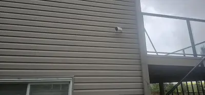 a security camera on the side of a building at Cozy and Affordable Apartment - Guesthouse South West Airdrie in Airdrie