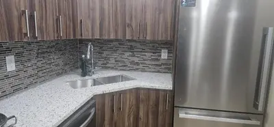 a kitchen with a sink and a stainless steel refrigerator at Cozy and Affordable Apartment - Guesthouse South West Airdrie in Airdrie