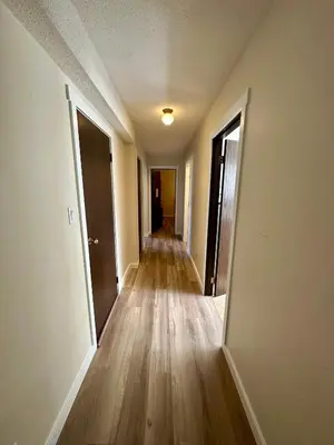 an empty hallway of an empty house with wooden floors at Beautiful home near City centre! in Kitimat
