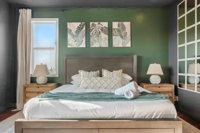 a bedroom with a large bed with green walls at Luxe & Lake 6BR Getaway Hot Tub Near the Lake in Sylvan Lake