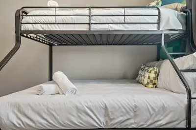 a bunk bed with two towels on the bottom bunk at Luxe & Lake 6BR Getaway Hot Tub Near the Lake in Sylvan Lake
