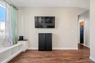 a living room with a flat screen tv on the wall at Luxe & Lake 6BR Getaway Hot Tub Near the Lake in Sylvan Lake