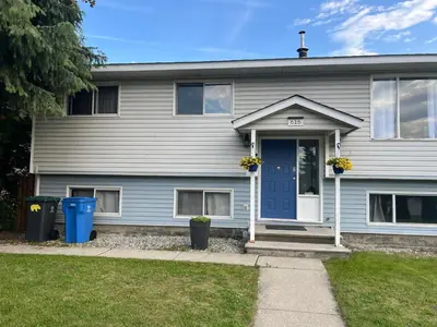a house with a blue door and two trash cans at Supinder's Rentals in Golden
