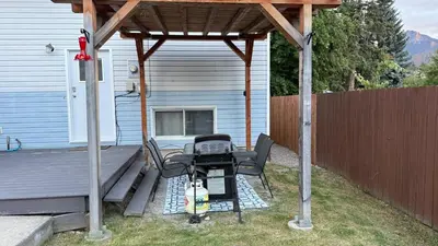 a barbecue grill under a pergola next to a house at Supinder's Rentals in Golden