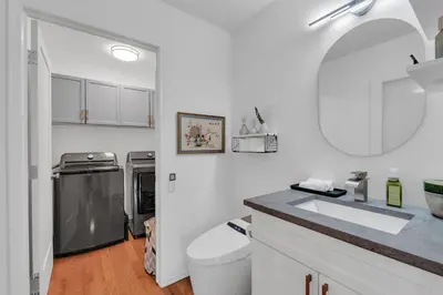 a white bathroom with a toilet and a sink at 1P Culture - Sara in Calgary