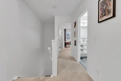 a hallway with white walls and a room with a table at 1P Culture - Sara in Calgary