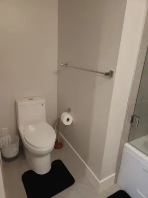 a white bathroom with a toilet and a shower at Central 2-Bedroom Townhouse Oak st in Vancouver