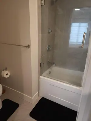 a bathroom with a shower and a tub and a toilet at Central 2-Bedroom Townhouse Oak st in Vancouver