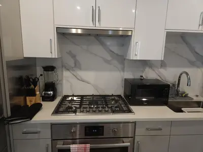 a kitchen with a stove top oven next to a microwave at Central 2-Bedroom Townhouse Oak st in Vancouver