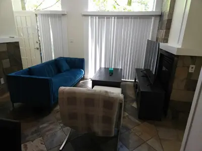 a living room with a blue couch and a fireplace at Central Townhouse Richards Street in Vancouver