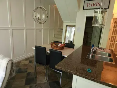 a kitchen with a counter with chairs and a sink at Central Townhouse Richards Street in Vancouver