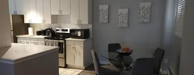 a kitchen with a table and a kitchen with a microwave at YYC : 2-Bedroom City Apartment in Calgary