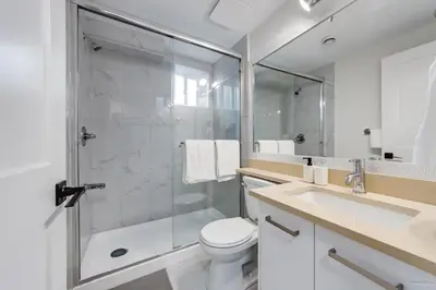 a bathroom with a shower and a toilet and a sink at Budget friendly 2-Bed 1-Bath Suite in New Westminster