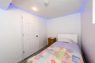 a bedroom with a bed and a blue string at 4 Bedroom Semi-basement Suite in Burnaby Metrotown in Burnaby