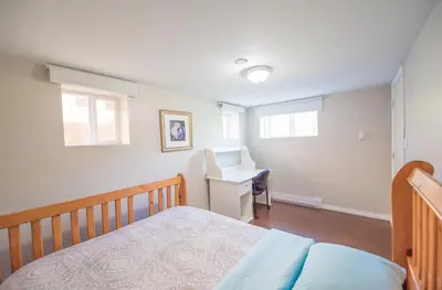 a bedroom with a bed and a desk at 4 Bedroom Semi-basement Suite in Burnaby Metrotown in Burnaby