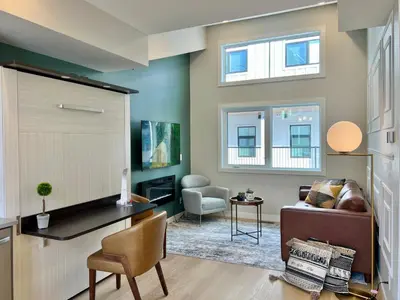 a living room with a couch and a table at Stunning View New Townhome Sleeps 11 AC and Hot Tub in Canmore