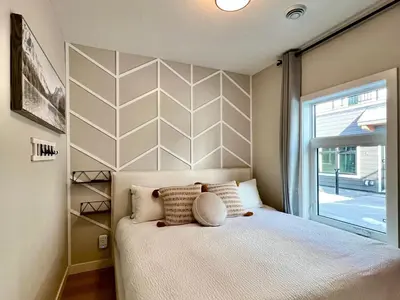 a bedroom with a bed and a large window at Stunning View New Townhome Sleeps 11 AC and Hot Tub in Canmore