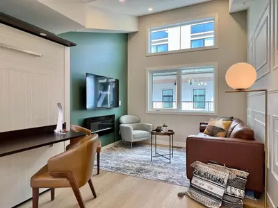 a living room with a couch and a tv at Stunning View New Townhome Sleeps 11 AC and Hot Tub in Canmore