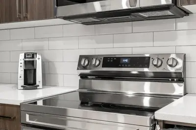 a stainless steel stove in a kitchen with a microwave at Lake Community Hideout in Chestermere