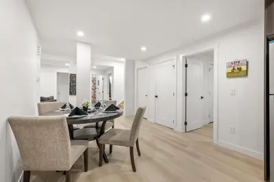 a dining room and living room with a table and chairs at Lake Community Hideout in Chestermere