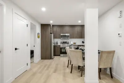 a kitchen and dining room with a table and chairs at Lake Community Hideout in Chestermere