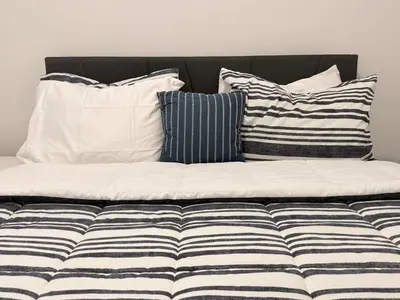 a couch with four pillows on top of it at 2 Bedroom snug retreat in Livingston Calgary Alberta in Calgary