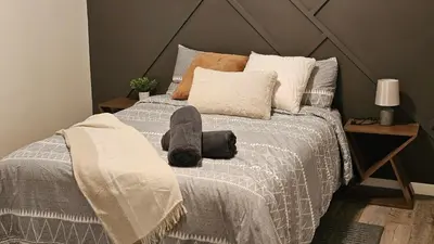 a bedroom with a bed with pillows at Modern Suite - Separate Entry - Self Check-In in Calgary