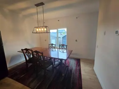 a dining room with a wooden table and chairs at Bedroom with TV in Upland E in Edmonton