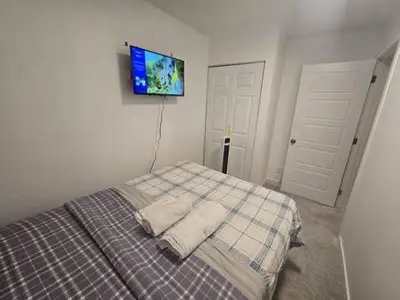 a bedroom with a bed with a tv on the wall at Bedroom with TV in Upland E in Edmonton