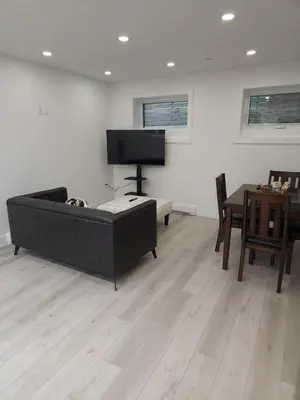 a living room with a black couch and a table at vistaeast 1-Bedroom Condo Rupert st in Vancouver