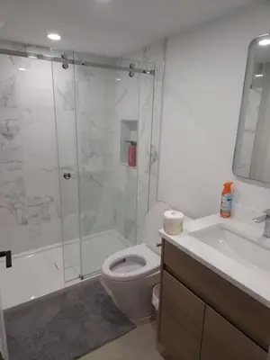 a bathroom with a shower and a toilet and a sink at vistaeast 1-Bedroom Condo Rupert st in Vancouver