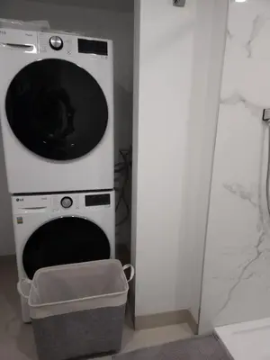 a washer and dryer in a bathroom with a door at vistaeast 1-Bedroom Condo Rupert st in Vancouver