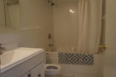 a bathroom with a tub and a toilet and a sink at Wildrose : 2-Bedroom City Apartment in Calgary