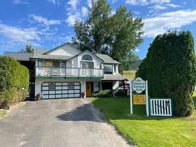 a house with a sign in the driveway at Country Cottage B&B in Vernon