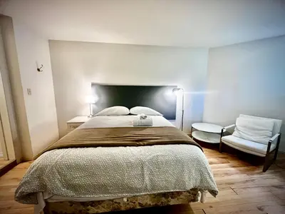 a bedroom with a large bed and a chair at Beautiful and cozy room in Vancouver in Vancouver